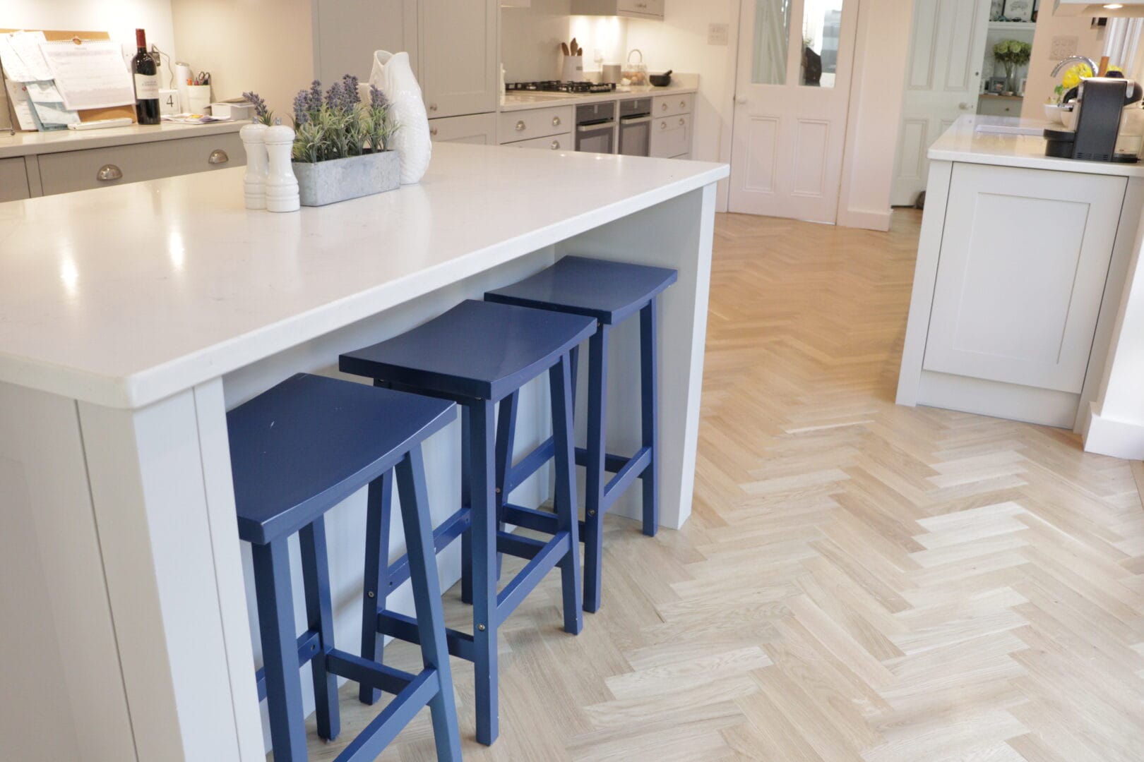 Oak herringbone flooring installation around a kitchen island in a Cambridge home.