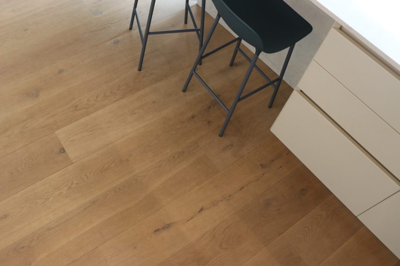 Engineered oak wood flooring in Cambridge kitchen with breakfast bar and dark bar stools.