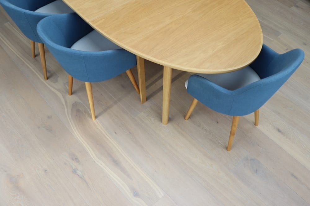 Engineered oak wood flooring in a modern Cambridge dining room with oval oak table and blue upholstered chairs.