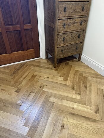 Detail of engineered oak herringbone flooring in Cambridge corner setting
