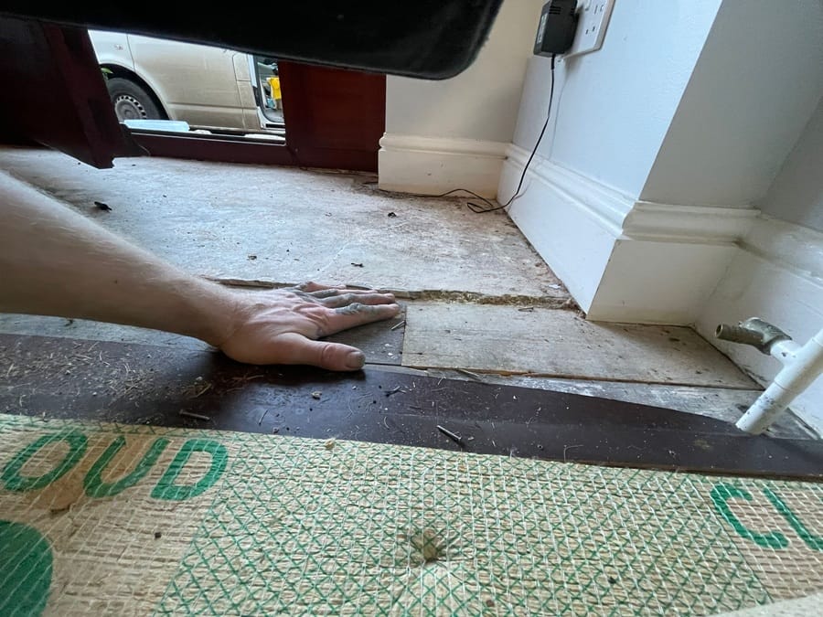 Patchwork subfloor close-up showing different materials meeting at the entrance
