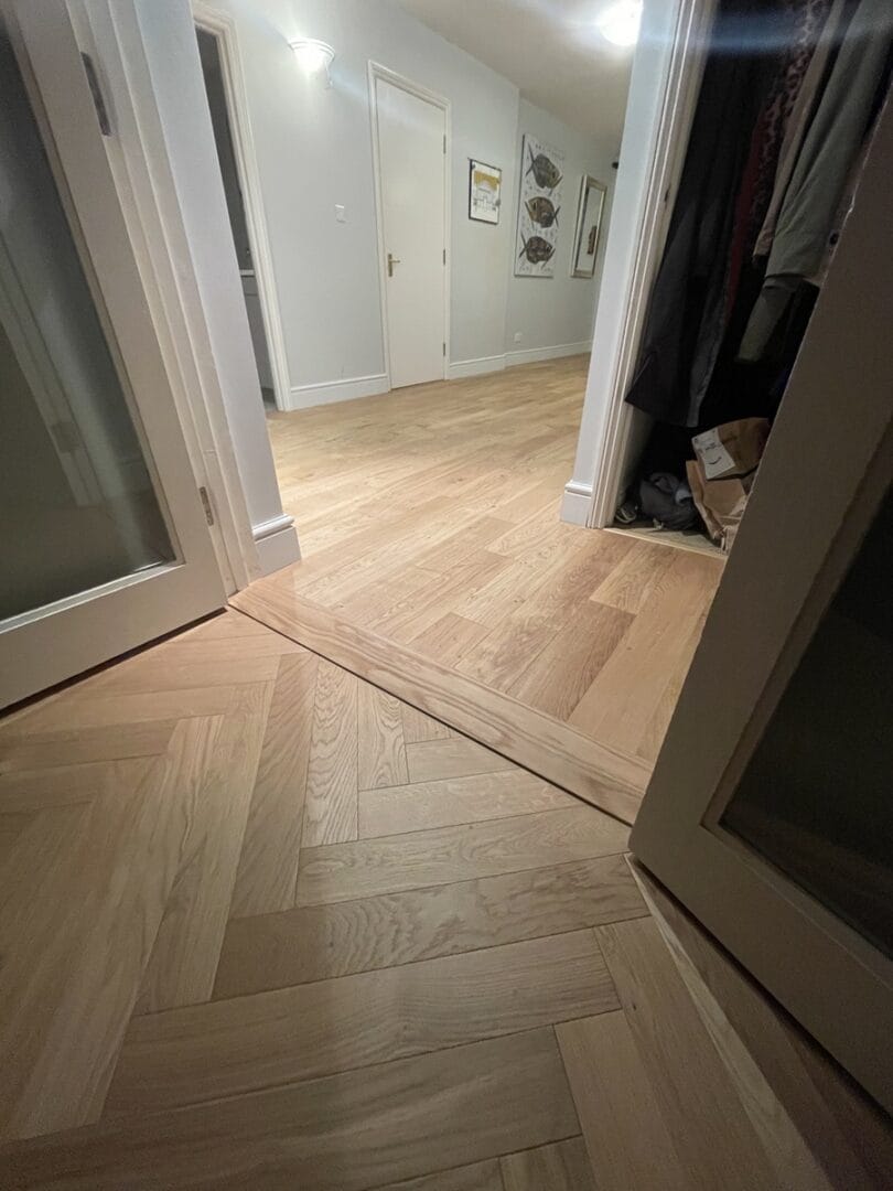Close view of oak threshold detail between herringbone and plank flooring