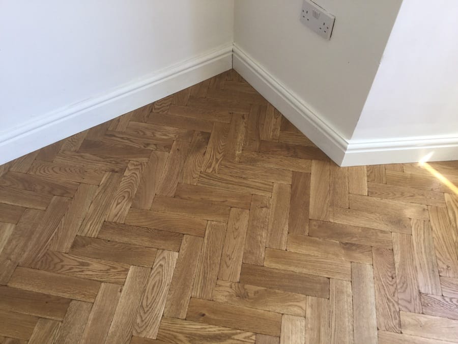 Solid oak herringbone parquet flooring installed in a Cambridge home corner detail
