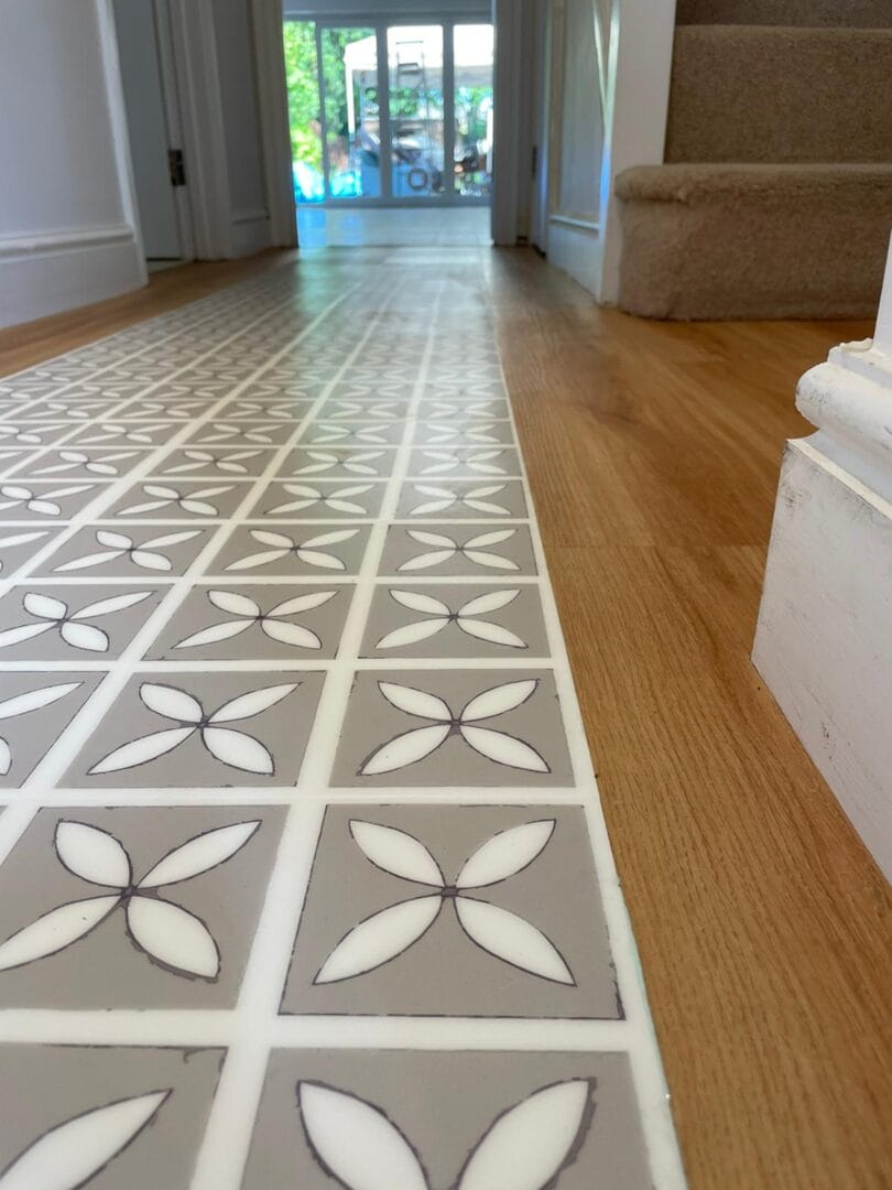 Patterned LVT hallway flooring with wood floor transition in Cambridge home