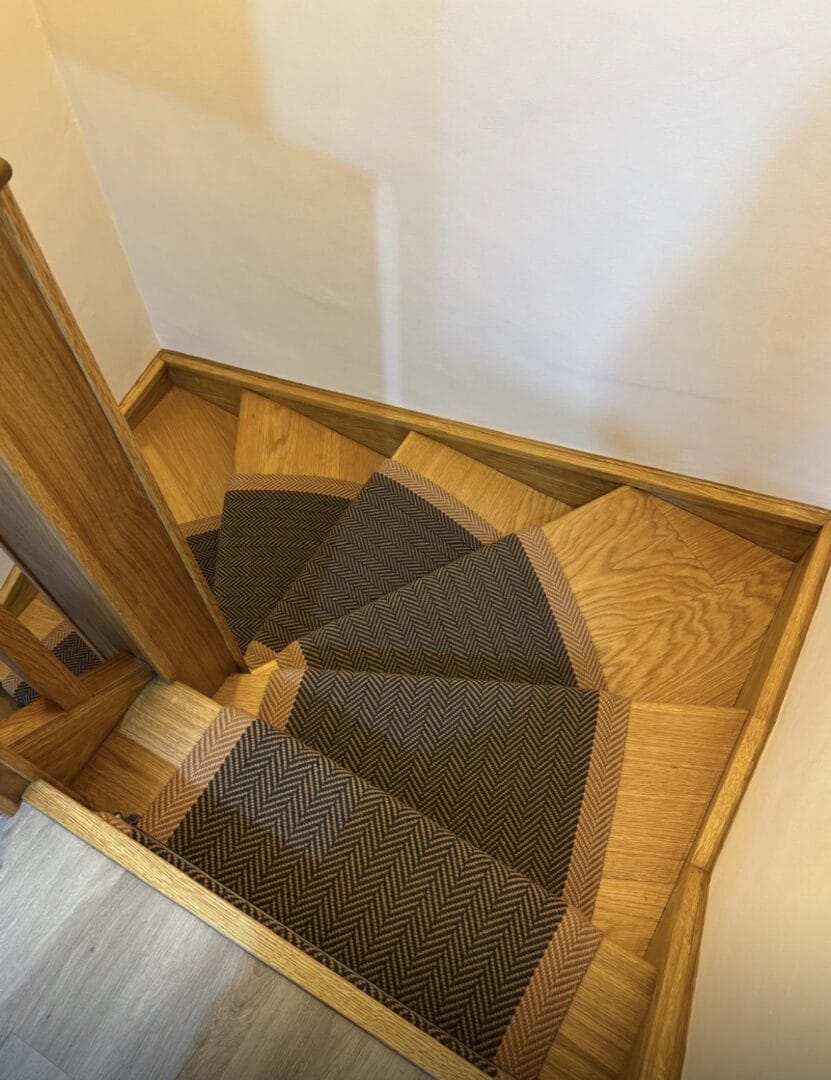 Carpet runner installation on curved oak staircase in Cambridge, adding a softer, safer feel underfoot with a herringbone design