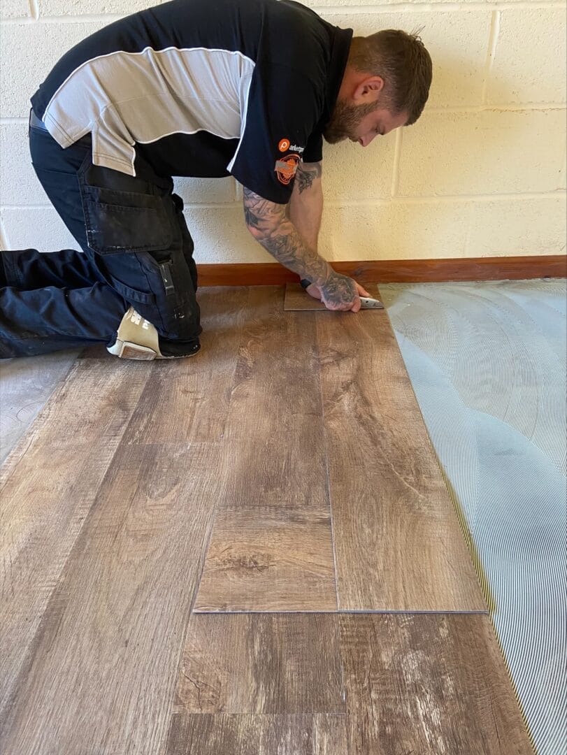 LVT flooring being carefully cut and fitted along the edge during installation in Cambridge