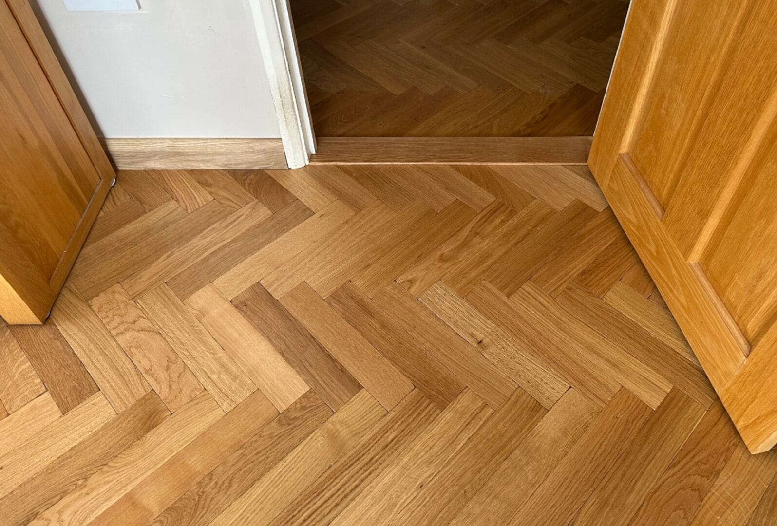 Oak herringbone flooring detail at doorway transition in a Cambridge home