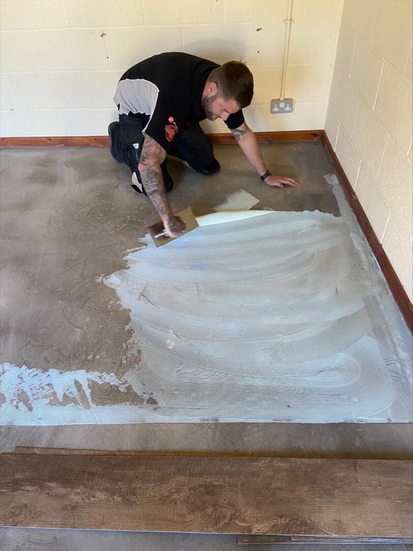 Adhesive being applied to subfloor before LVT installation in Cambridge