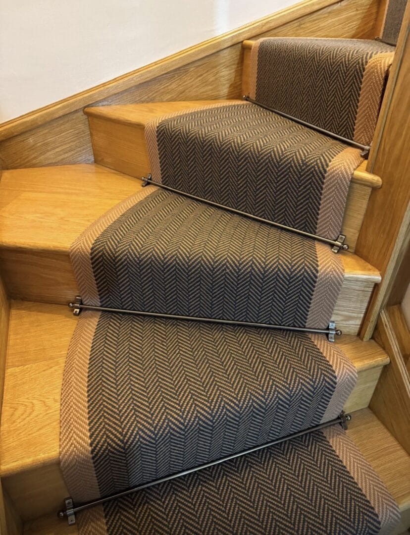 Carpet runner with border and stair rods on oak staircase in Cambridge, combining a neat finish with added comfort and safety