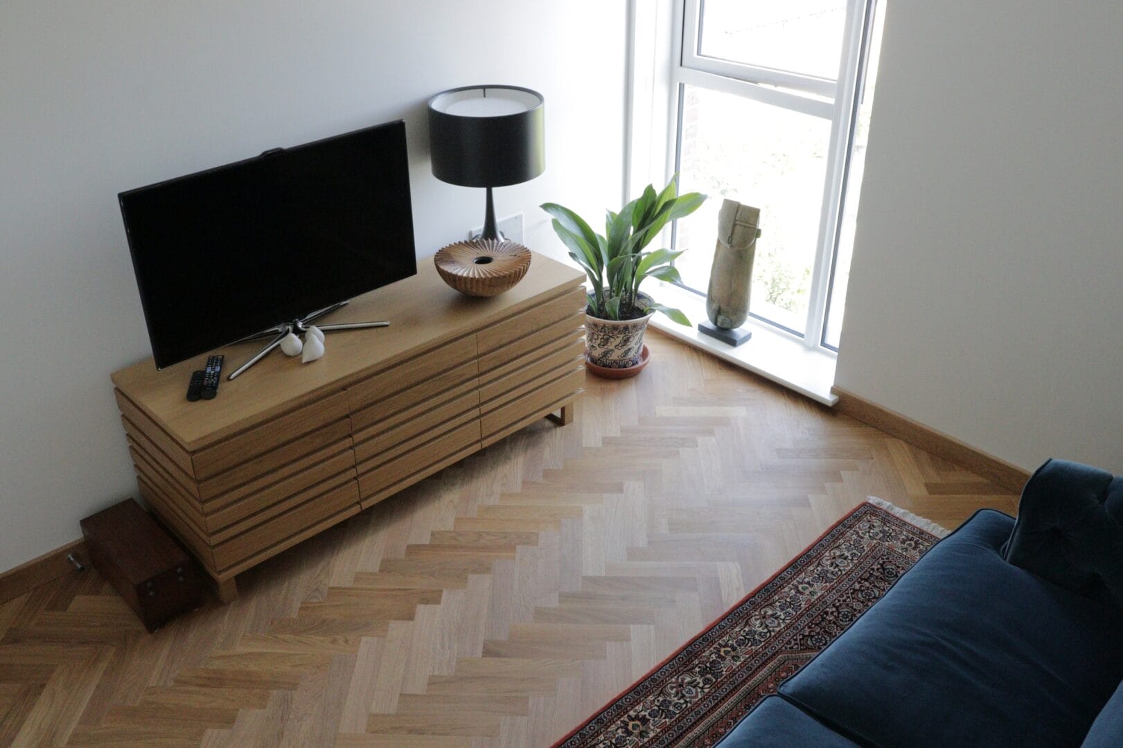 Herringbone wood flooring in a Cambridge living room with natural light and furniture