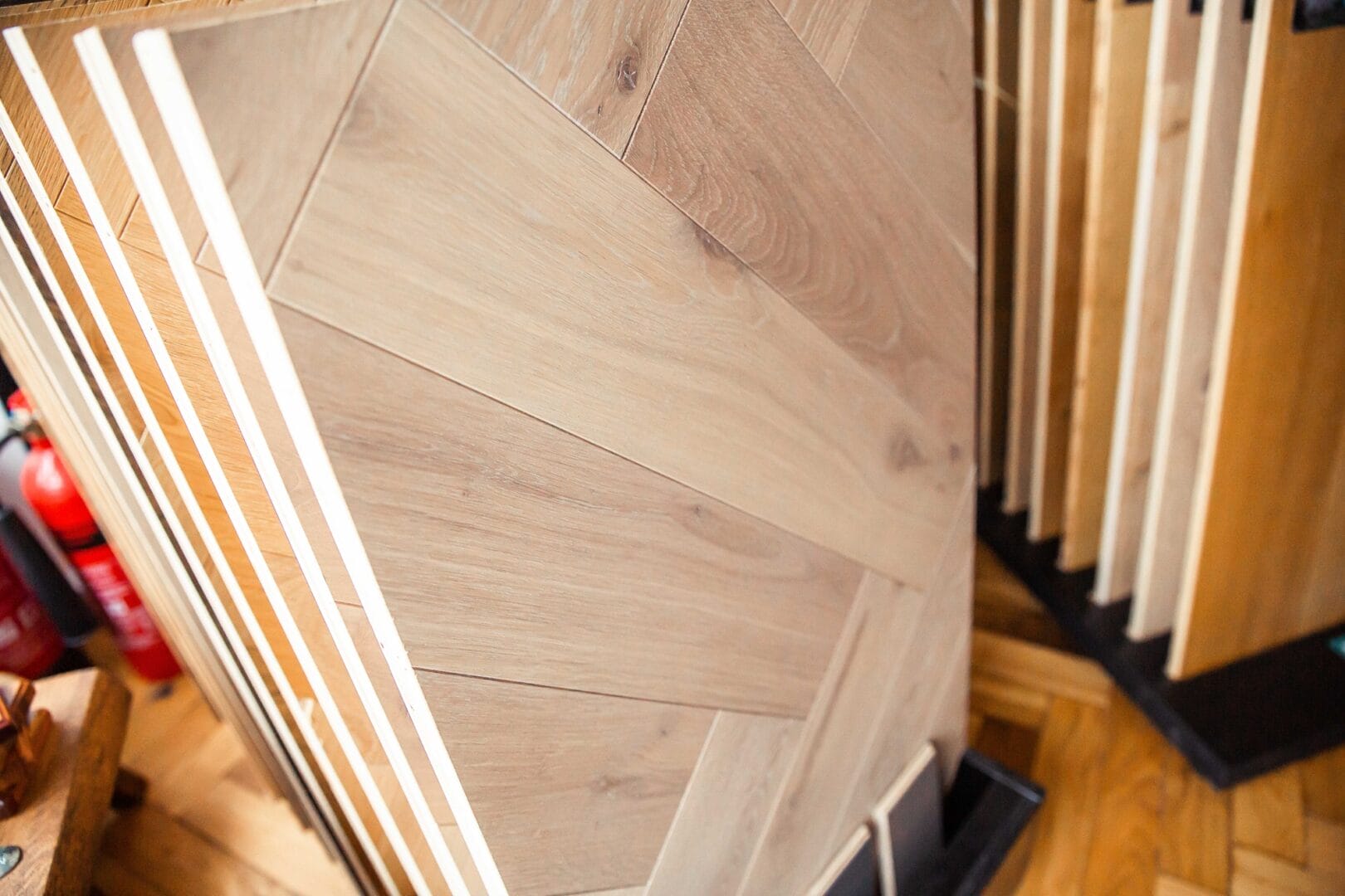 Light oak herringbone flooring panel displayed in the Art of Flooring showroom