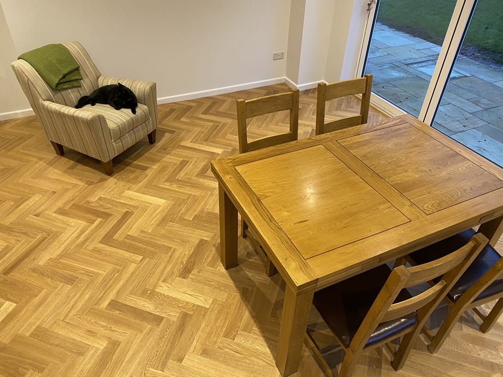 Oak herringbone flooring fitted through a Cambridge dining area with table and chairs