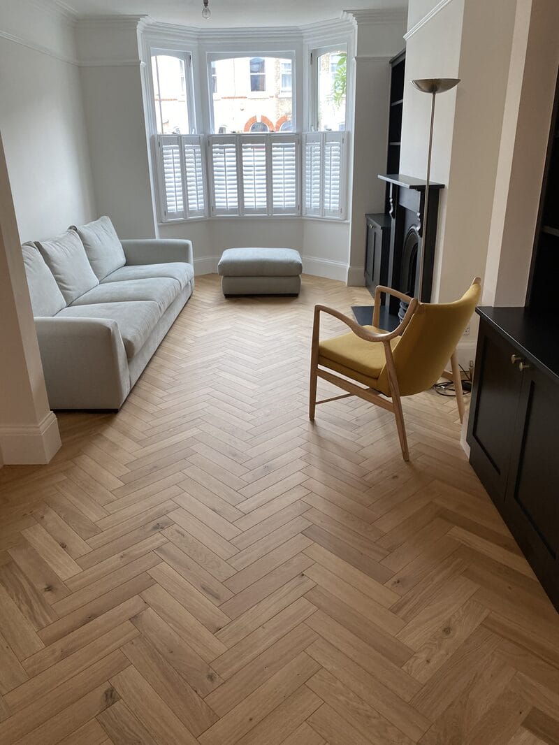 Oak herringbone flooring installed in a Victorian living room in London.