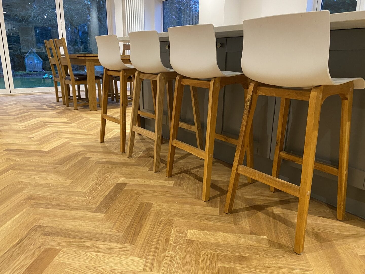 Oak herringbone flooring installed in an open-plan kitchen and dining area in Essex.