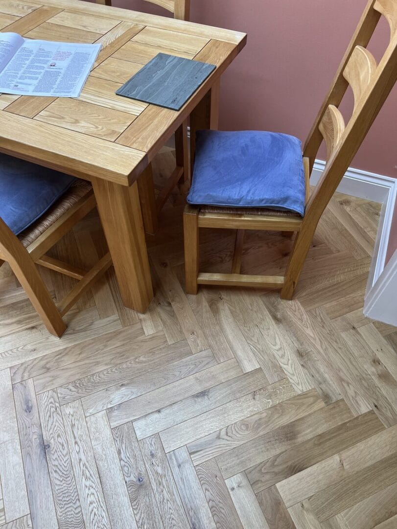 Engineered oak herringbone flooring fitted beneath a dining table in a Cambridge family home.