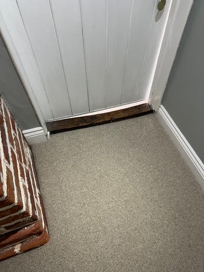 Natural loop carpet fitted neatly up to a white cottage doorway in Cambridge.