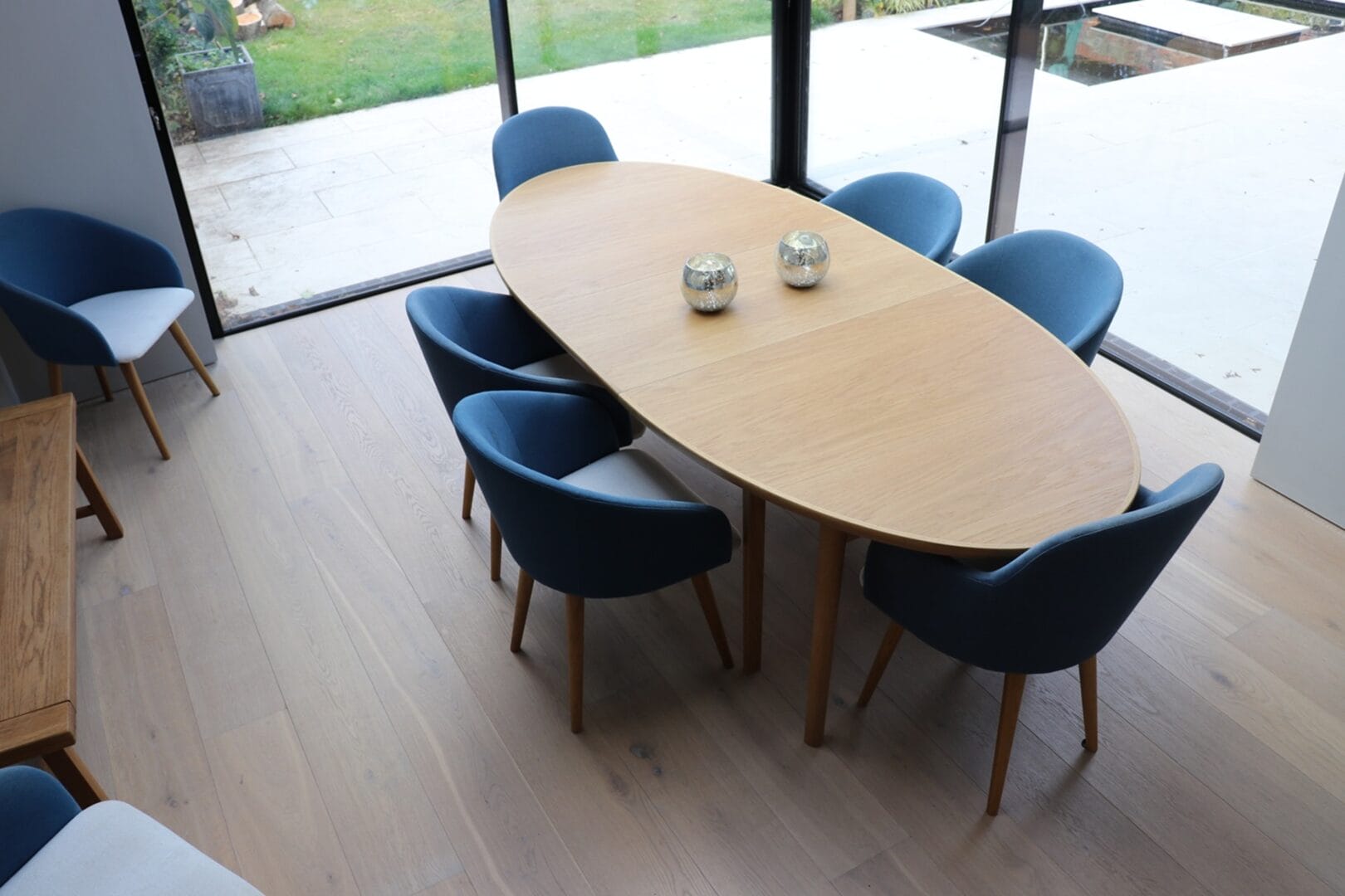 Dining area with blue chairs on light oak floor finish in Cambridge
