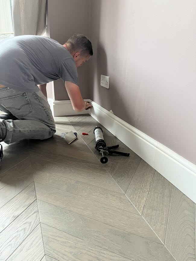 Skirting board fitting during wood flooring installation in Cambridge