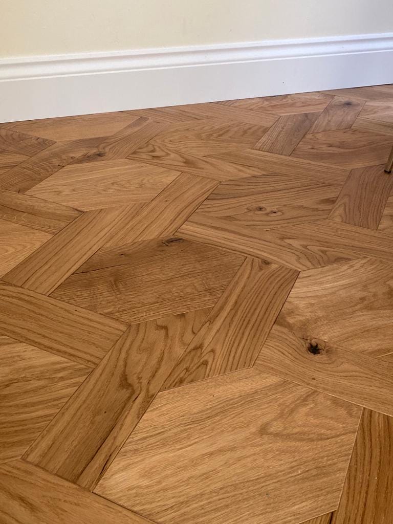 Bespoke patterned oak parquet flooring with interlocking geometric shapes.