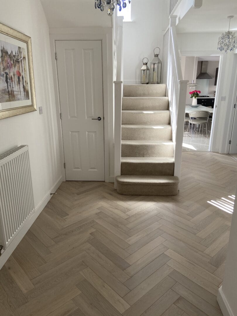 Finished light oak herringbone flooring in a bright Cambridge hallway.