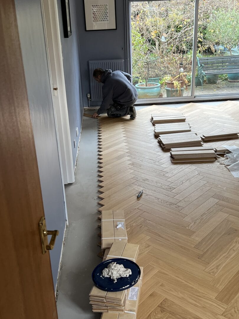Flooring specialist fitting oak herringbone boards in a Cambridge home.