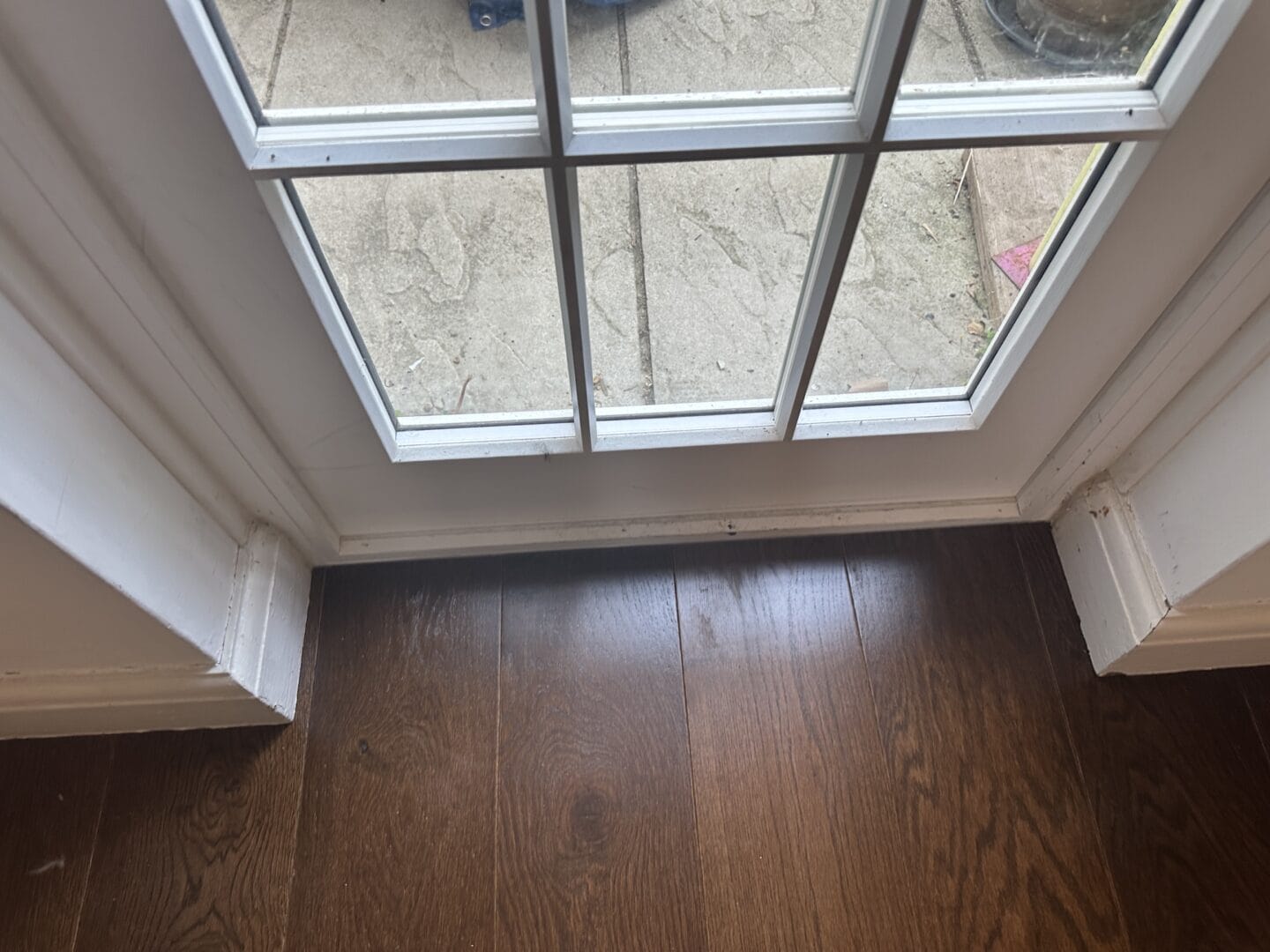Walnut engineered flooring fitted neatly beside a glazed patio door