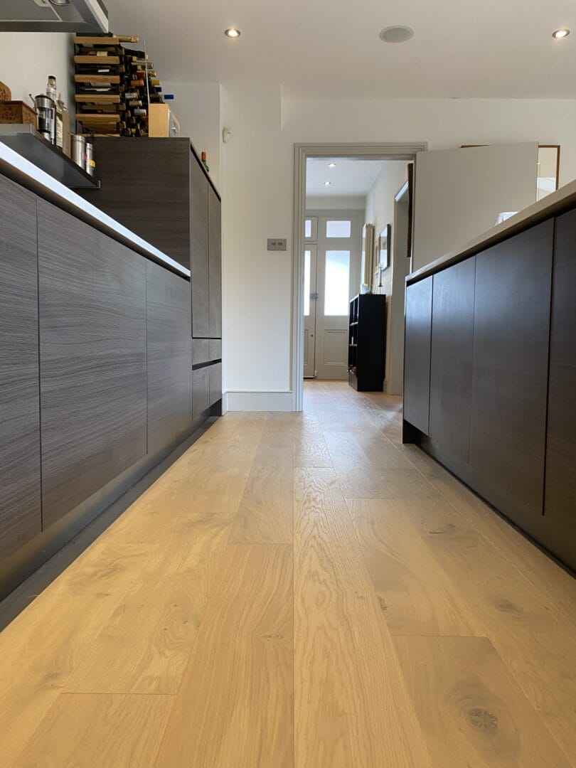 Ash engineered wood floor running through a kitchen into the hallway of a Cambridge home