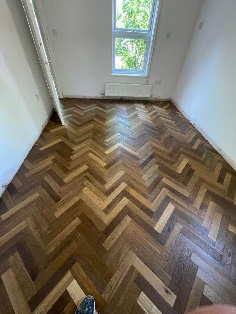 Wide view of a Cambridge bedroom with fully restored oak herringbone parquet flooring