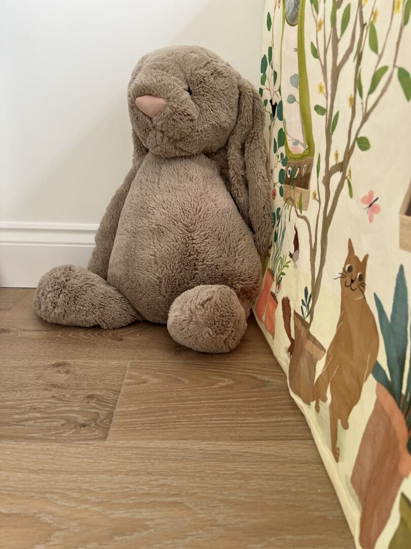 Close-up of engineered wood flooring in a children's room with a soft toy rabbit