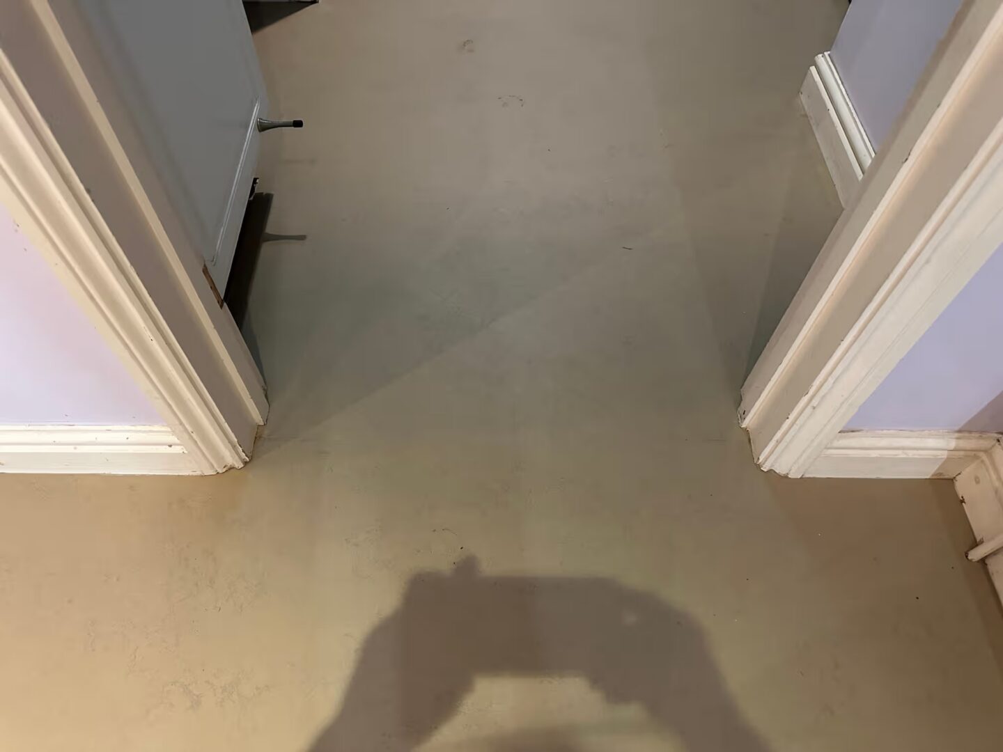 Smooth levelled subfloor running through a doorway between two rooms with white door frames